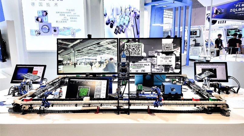 主展桌展示一个正在运作的玩具工厂,其中包含The Imaging Source工业相机产品系列的各式相机: 变焦相机,FPD-Link™ III相机模组 (嵌入式视觉),33系列和37系列。